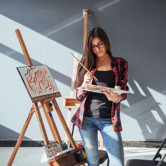 Estudia artes y humanidades en universidades en España para extranjeros Estudiante pintando en un estudio de arte en una universidad de España